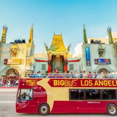 Big Bus Los Angeles tour bus passes by the iconic TCL Chinese Theatre on Hollywood Boulevard