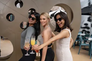 Ladies enjoying mimosas with a Scarlett Johansson wax figure at Hollywood Rooftop Bar, Madame Tussauds